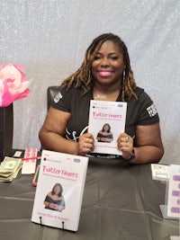 a woman sitting at a table holding a book